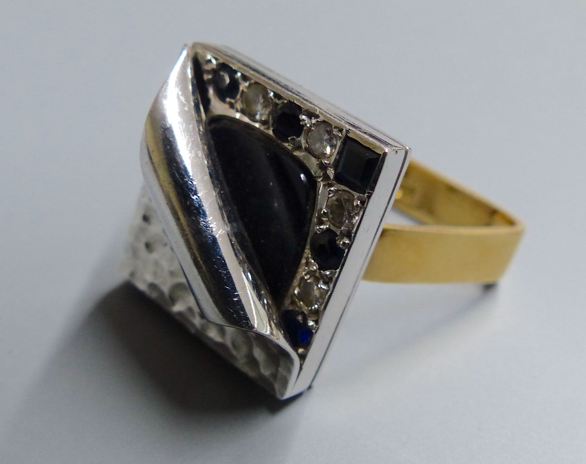 An unusual white metal, black onyx?, sapphire and diamond set square cluster ring